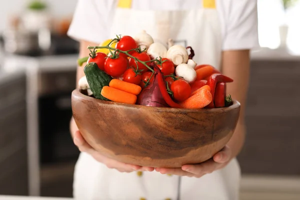 Cute little chef with vegetables in kitchen, closeup