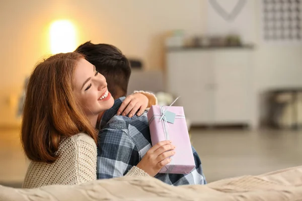 Pareja Joven Con Caja Regalo Abrazándose Casa Celebración Del Día — Foto de Stock