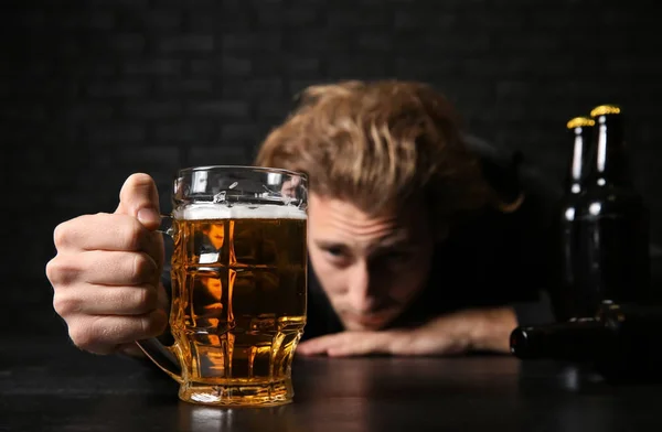 Pijany Młody Człowiek Piwem Przy Stole Pobliżu Czarny Ceglany Mur — Zdjęcie stockowe
