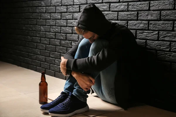 Giovane Depresso Con Bottiglia Birra Seduto Sul Pavimento Vicino Muro — Foto Stock