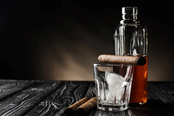Bicchiere Con Ghiaccio Bottiglia Whisky Sigari Tavolo Legno Sfondo Scuro — Foto Stock