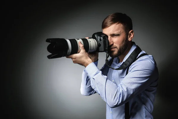 Detective with professional photo camera on dark background