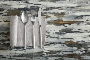 Ahşap arka planda çatal bıçak ve peçete.