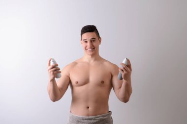 Deodorantlar ışık arka plan üzerinde olan genç adam