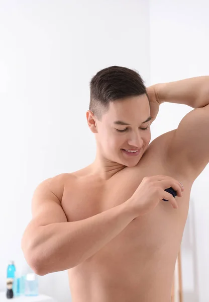 Ung Man Använder Deodorant Badrum — Stockfoto