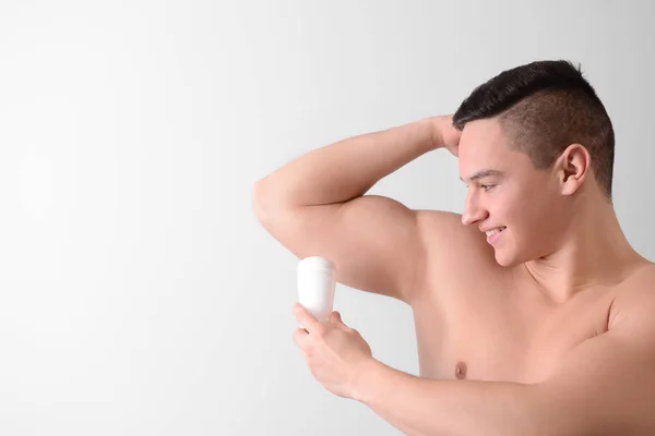 Młody Człowiek Dezodorant Jasnym Tle — Zdjęcie stockowe