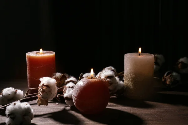 Beautiful burning candles and cotton flowers on wooden table