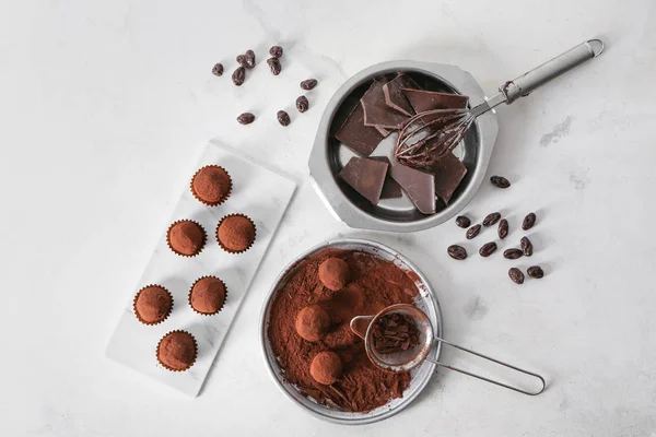 Tasty sweet truffles with cacao powder and chocolate on light table