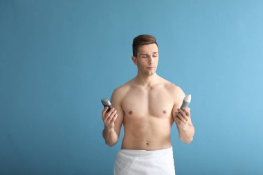 Yakışıklı delikanlı ile renk arka plan üzerinde farklı deodorantlar