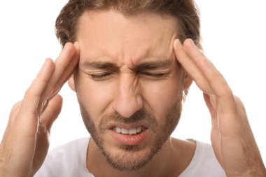 Genç adam beyaz arka planda, closeup baş ağrısı muzdarip