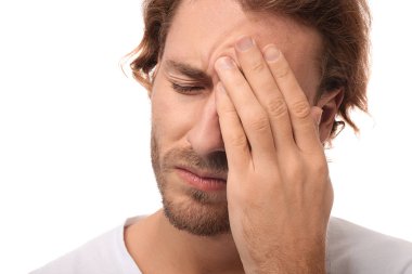 Genç adam beyaz arka planda, closeup baş ağrısı muzdarip