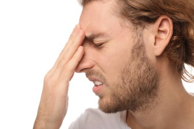 Genç adam beyaz arka planda, closeup baş ağrısı muzdarip