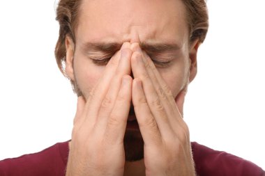 Genç adam beyaz arka planda, closeup baş ağrısı muzdarip