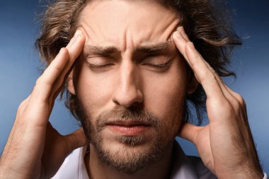 Genç adam renk arka plan, closeup üzerinde baş ağrısı muzdarip