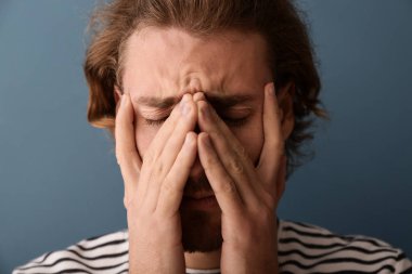 Genç adam renk arka plan, closeup üzerinde baş ağrısı muzdarip