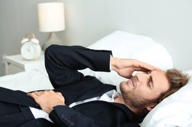 Genç işadamı yatak odasında baş ağrısı muzdarip