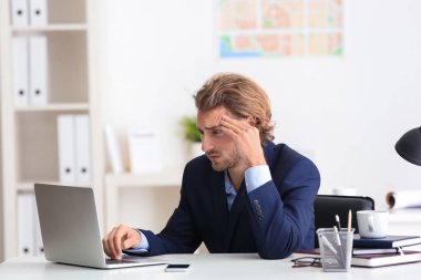 ofiste baş ağrısı çeken genç işadamı
