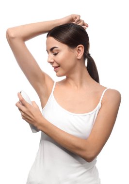 Beyaz arka plan üzerinde deodorant kullanan genç kadın
