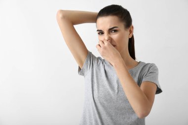 Güzel ve genç birbayan duygu beyaz arka plan üzerinde ter kokusu. Deodorant kullanmanın kavramı