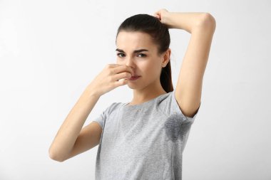Güzel ve genç birbayan duygu beyaz arka plan üzerinde ter kokusu. Deodorant kullanmanın kavramı