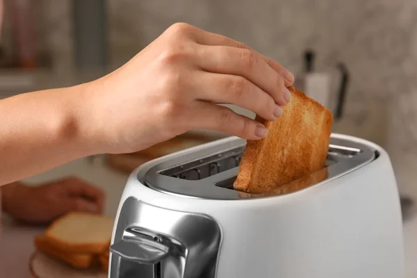 Woman preparing toasts for breakfast in kitchen