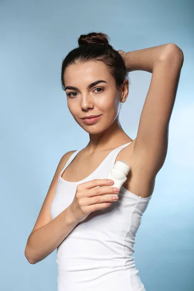 Mujer Joven Usando Desodorante Sobre Fondo Color — Foto de Stock