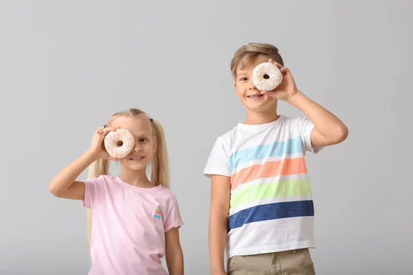 Niedliche Kleine Kinder Mit Donuts Auf Hellem Hintergrund — Stockfoto