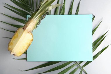 Olgun kesme ananas, palmiye yaprağı ve gri arka plan üzerinde boş kartı