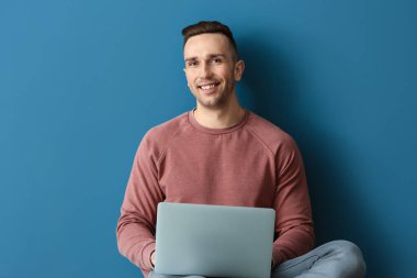Dizüstü bilgisayarı olan genç bir adam.