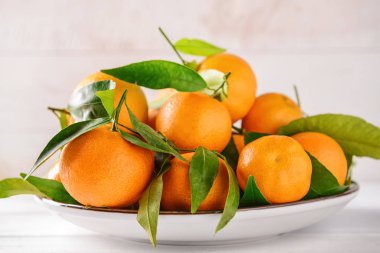 Işık tablosu üzerinde lezzetli mandalina ile plaka