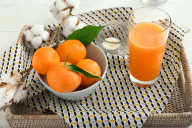 Bir kase lezzetli mandalina ve bardak suyu hasır tepsi