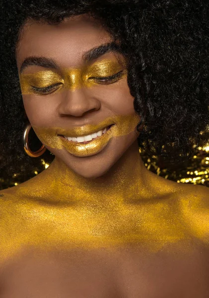 African-American woman with golden paint on her body