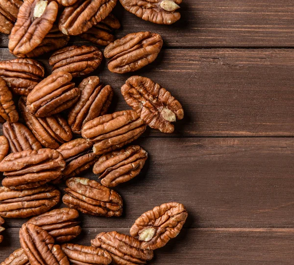 Pecan nuts on wooden background