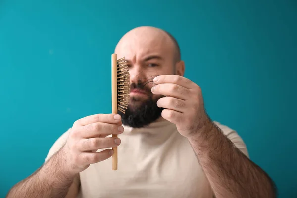 Man with hair loss problem on color background