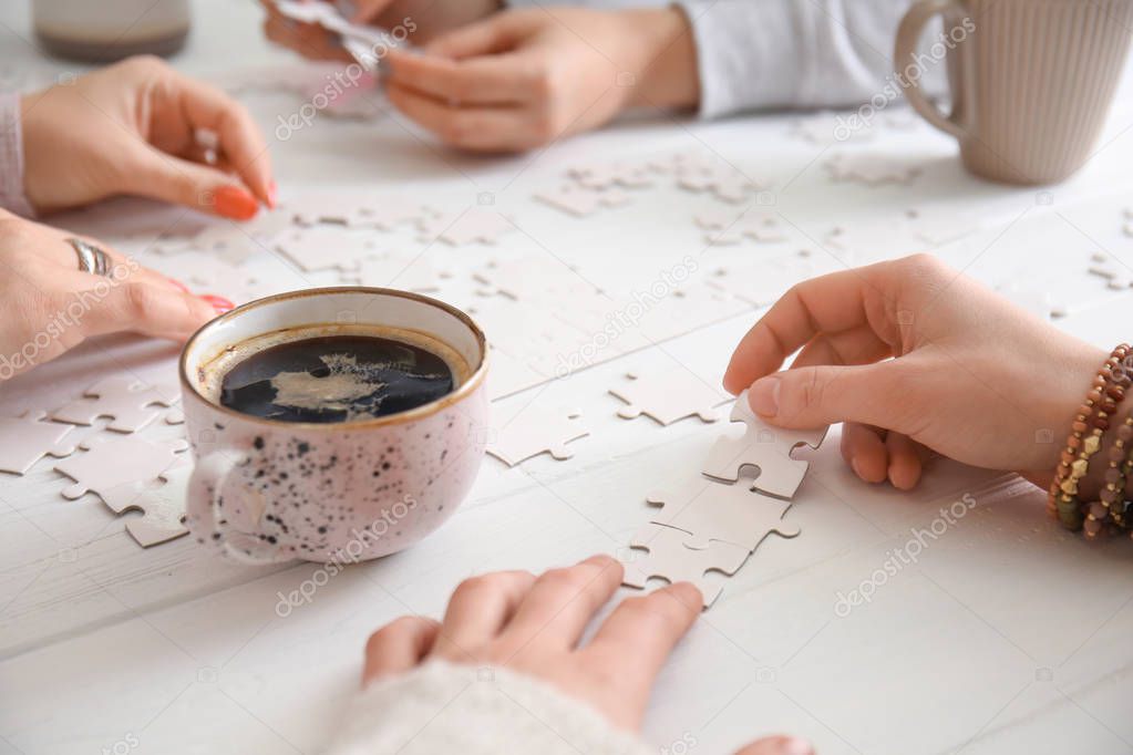 People doing puzzle at table
