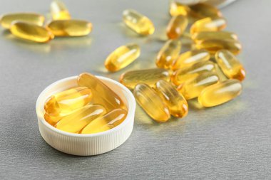 Gri arka plan üzerinde haplarla plastik kap