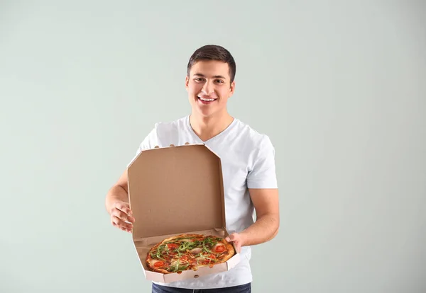 Young Man Holding Box Tasty Pizza Light Background — Stock Photo, Image