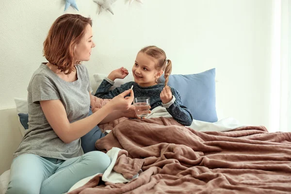 Junge Frau Gibt Pille Für Ihre Kranke Tochter Bett — Stockfoto