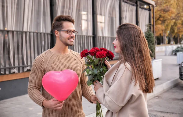 年轻夫妇与美丽的玫瑰花束户外 — 图库照片