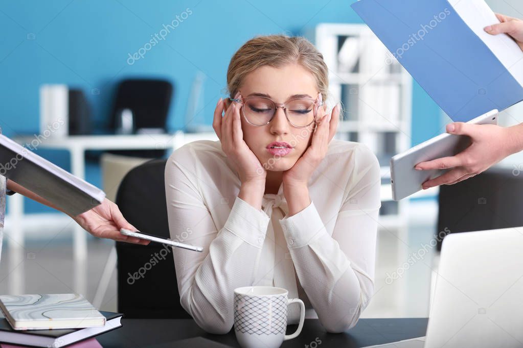 Stressed businesswoman with a lot of work in office