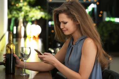 Cep telefonu barda alkol ile depresif kadın