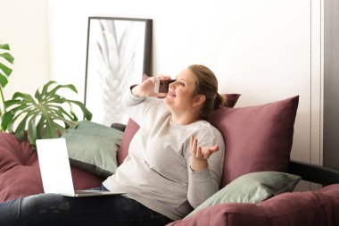 Güzel artı boyutu kız evde cep telefonuyla konuşuyor. Vücut olumluluk kavramı