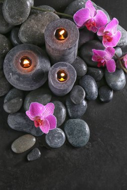 Taşlar, mumlar ve çiçekler koyu arka plan üzerinde güzel spa kompozisyonu