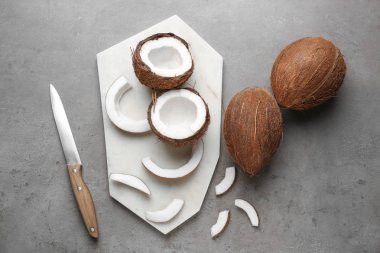 Olgunlaşmış hindistancevizi ve gri arka plan üzerinde kesme tahtası kompozisyonu