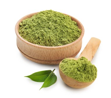 Beyaz arka planda pudralanmış kibrit çayı ile kase ve kaşık.