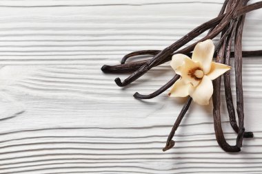 Aromatik vanilya beyaz ahşap arka plan üzerinde sopa