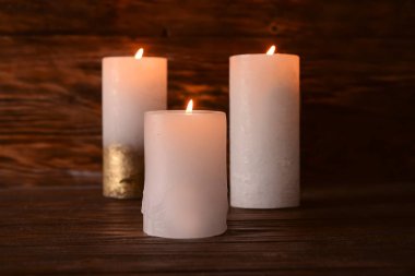 Karanlığın içinde ahşap masa üzerinde yanan mumlar