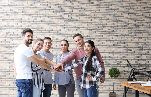 Jóvenes Poniendo Manos Juntas Oficina —  Fotos de Stock