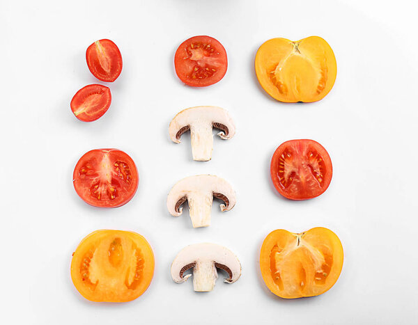 Cut tomatoes and mushrooms on white background, flat lay