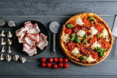 Pizza ve malzemeler ahşap arka plan üzerinde düz yatıyordu kompozisyonu